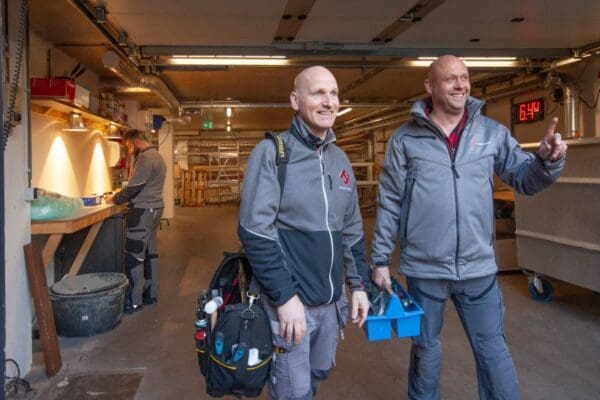 Twee mannen in werkkleding met gereedschap.