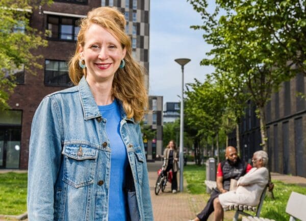 Vrouw staand op straat op achtergrond mensen op bankje