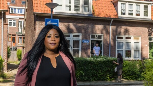 Vrouw staand in straat met woningen